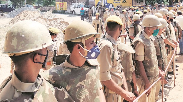 Police personnel deployed outside the victim’s village in Hathras on Friday. (Express photo: Amil Bhatnagar)