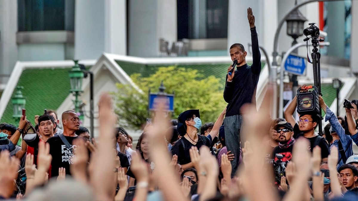 A man raises three-finger salutes, a symbol of resistance, as he speaks to pro-democracy protesters during a protest at the central business district in Bangkok, Thailand, Thursday, Oct. 15, 2020.  (AP)