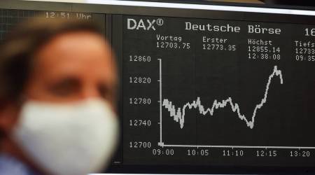 A trader wears a protective face mask near the DAX Index curve inside the Frankfurt Stock Exchange, operated by Deutsche Boerse AG, in Frankfurt, Germany, on Friday, Oct. 16, 2020. (Photographer: Alex Kraus/Bloomberg)
