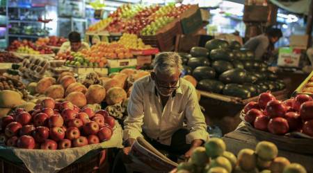A vendor reads a newspaper while sitting at a fruit stall at Crawford Market in Mumbai, India, on Tuesday, Dec. 11, 2018. (Photographer: Dhiraj Singh/Bloomberg)