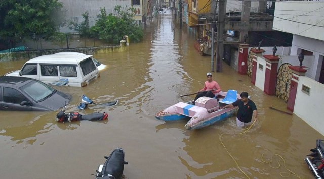 Buildings and vehicles lie partially submerged in floodwater following heavy rains at Falaknuma in Hyderabad, Wednesday. (PTI)