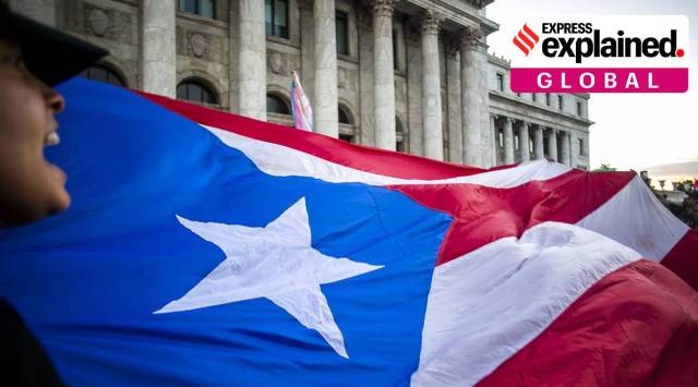 Demonstrators hold a large Puerto Rican flag outside the Capitol building during a protest against the government Puerto Rico (Photographer: Xavier Garcia/Bloomberg)