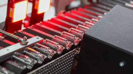 Glass vials move along a conveyor at the Gerresheimer AG medical glassware factory in Buende, Germany. (Photographer: Alex Kraus/Bloomberg)