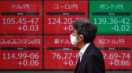 A man walks past an electronic stock board showing foreign currency prices at a securities firm in Tokyo Thursday, Nov. 12, 2020. (AP Photo/Eugene Hoshiko)