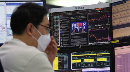 A screen shows Democratic presidential candidate former Vice President Joe Biden during a news program about the US elections as a currency trader works at the foreign exchange dealing room of the KEB Hana Bank headquarters in Seoul, South Korea, Friday, Nov. 6, 2020. (AP Photo/Ahn Young-joon)