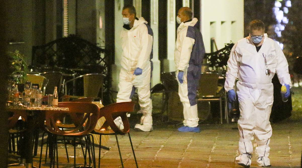 Three persons investigate at the scene following gunfire on people enjoying a last evening out before lockdown in the Austrian capital Vienna, early Tuesday, Nov. 3, 2020. (AP Photo/Ronald Zak)