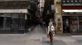 A woman wearing a face mask to help curb the spread of the coronavirus walks in Centre Place in Melbourne, Australia (Photo: AP)