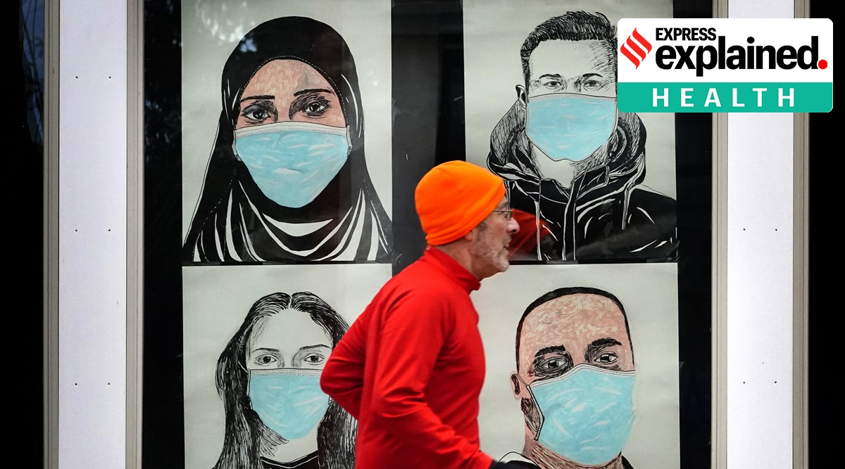 A runner passes by a window displaying portraits of people wearing face coverings to help prevent the spread of the coronavirus, Monday, Nov. 16, 2020, in Lewiston, Maine. (AP Photo: Robert F. Bukaty)
