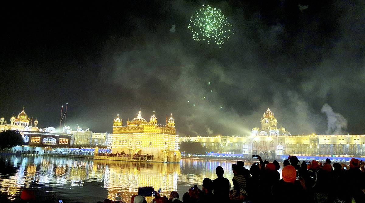 Sikh devotees watch firework at Harmandir Sahib (Golden Temple) on the occasion of 'Bandi Chhor Divas' (Day of Liberation), a Sikh festival coinciding with Diwali, in Amritsar, Saturday, Nov. 14, 2020. (PTI Photo)