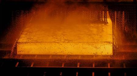 A red hot steel slab passes along a rolling machine inside a steel factory in India. (Photographer: Dhiraj Singh/Bloomberg)