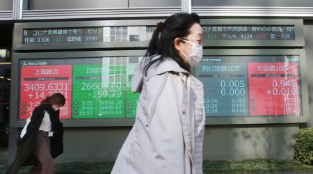 People walk by an electronic stock board of a securities firm in Tokyo, Monday, Dec. 21, 2020. (AP Photo/Koji Sasahara)