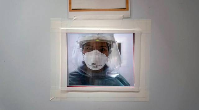 Registered nurse Nicole Grecco looks through a small window while working in a COVID-19 unit at Mission Hospital in Mission Viejo, Calif., Monday, Dec. 21, 2020. (AP Photo/Jae C. Hong)