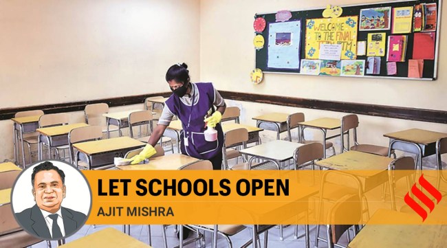 A school employee sanitises desks amid the Covid-19 pandemic. (Express Photo/File)