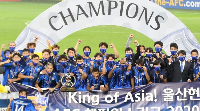 Ulsan Hyundai's players pose with a trophy after the AFC Champions League final match against Persepolis in Al Wakrah, Qatar, Saturday, Dec. 19, 2020. (AP Photo/Hussein Sayed)