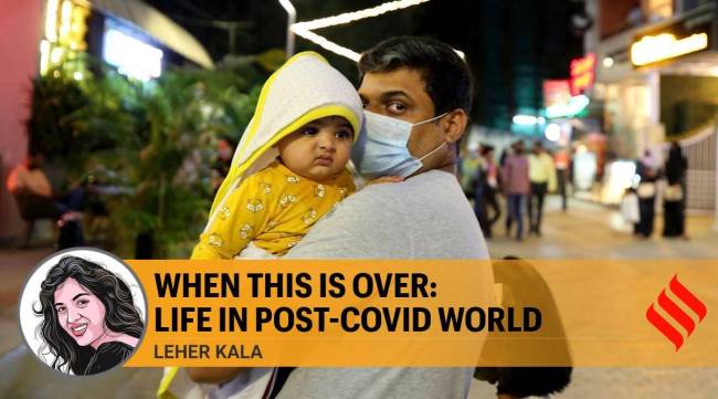 A man wearing a face mask as a precaution against the coronavirus carries a baby without a mask on a street open only to pedestrians during weekends in Bengaluru. (AP Photo/Aijaz Rahi)
