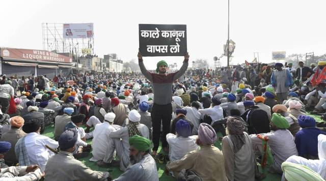 A farmer holds a placard at Singhu border during 'Delhi Chalo' protest march against the Centre's new farm laws, in New Delhi, Wednesday, Dec. 2, 2020. (PTI Photo/ Manvender Vashist)