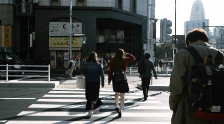 Pedestrians walk across a road in the Shinjuku district of Tokyo, Japan, on Thursday, Nov. 19, 2020. (Photographer: Soichiro Koriyama/Bloomberg)