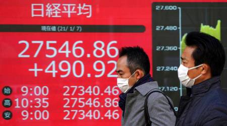 People walk past an electronic stock board showing Japan's Nikkei 225 index at a securities firm in Tokyo Thursday, Jan. 7, 2021. Shares rose in Asia on Thursday after Wall Street rallied on expectations of more stimulus for the economy, despite chaotic scenes in Washington as Trump supporters stormed the US Capitol. (AP Photo/Eugene Hoshiko)