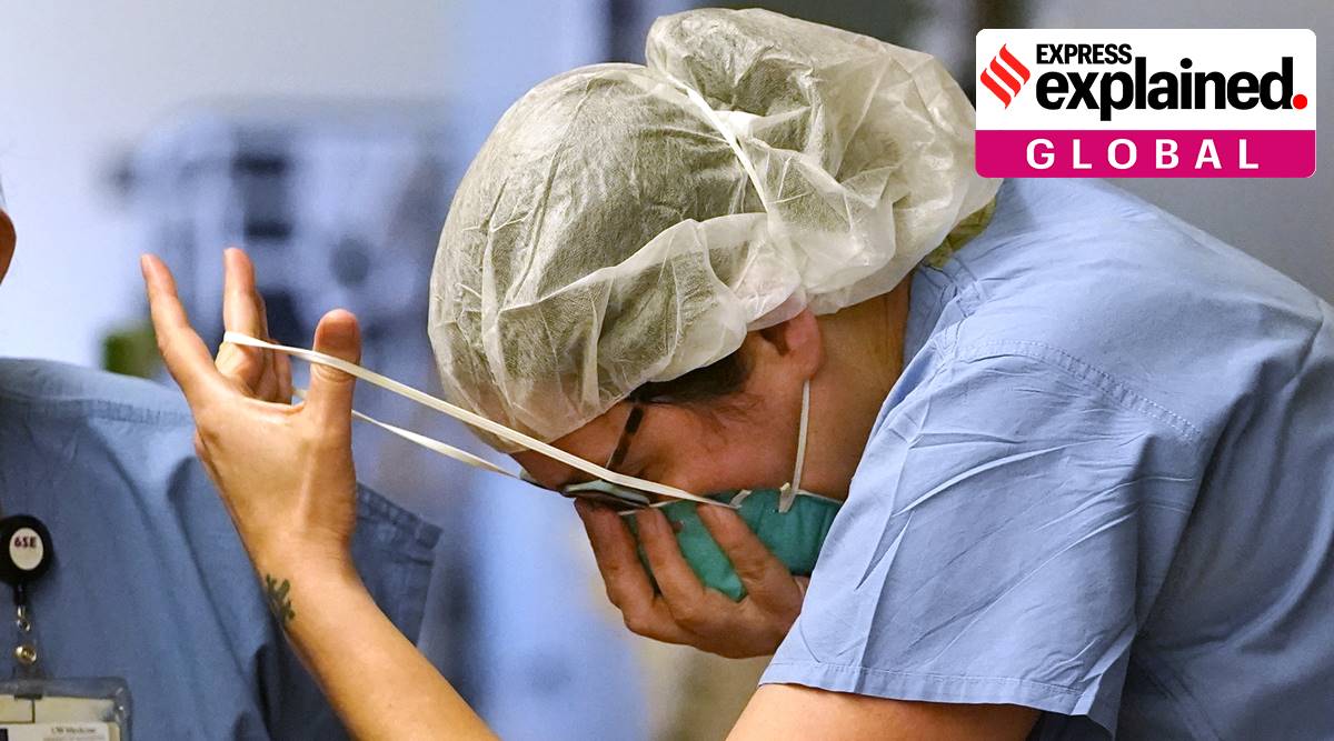 A nurse pulls on an N-95 mask as she enters the "red zone" before heading into a patient's room in the COVID Acute Care Unit at UW Medical Center - Montlake, Tuesday, Jan. 26, 2021, in Seattle. (AP Photo/Elaine Thompson)