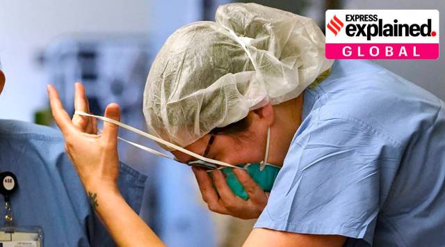A nurse pulls on an N-95 mask as she enters the "red zone" before heading into a patient's room in the COVID Acute Care Unit at UW Medical Center - Montlake, Tuesday, Jan. 26, 2021, in Seattle. (AP Photo/Elaine Thompson)