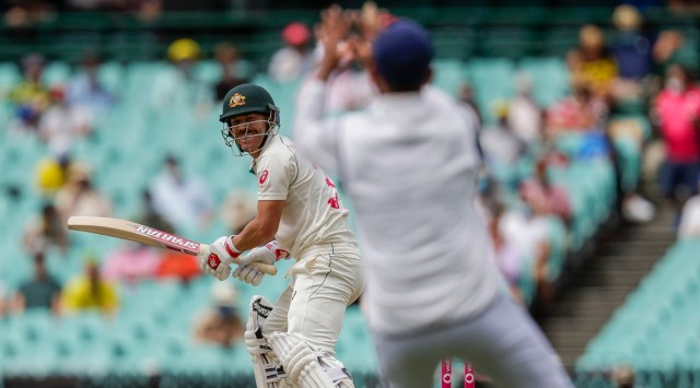 Australia's David Warner, left, watches as he hits the ball to India's Cheteshwar Pujara to be out caught for five runs. (AP Photo)
