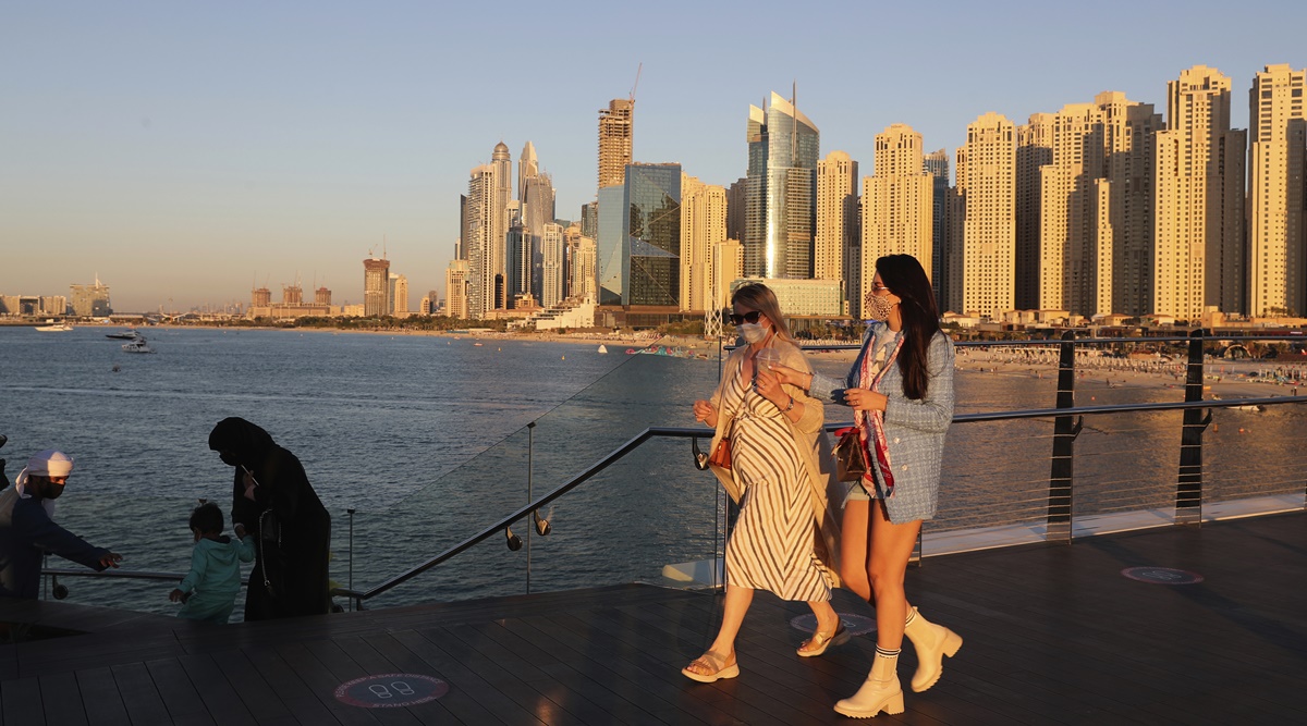 Tourists walk by an Emirati family in Dubai, United Arab Emirates, Tuesday, Jan. 12, 2021.  (AP)