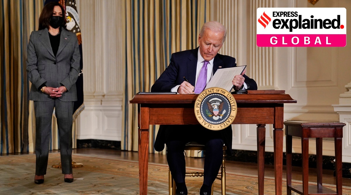 President Joe Biden signs executive orders in the State Dining Room of the White House, Tuesday, Jan. 26, 2021, in Washington. Vice President Kamala Harris listens at left. (AP Photo/Evan Vucci)