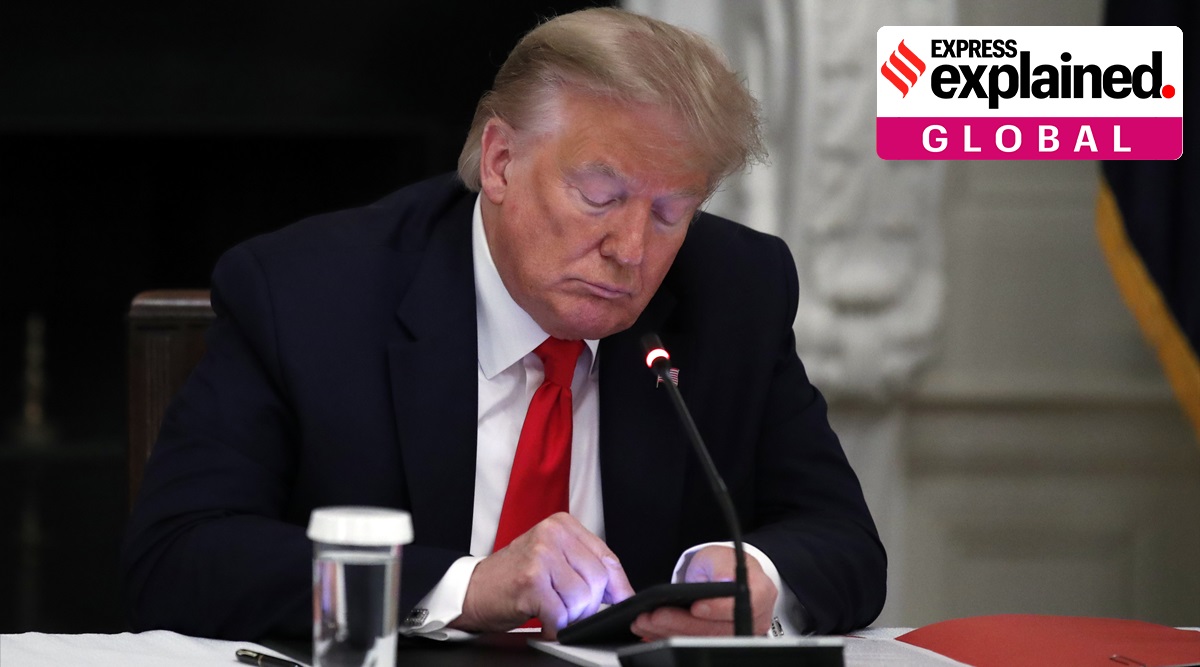 President Donald Trump looks at his phone, in the State Dining Room of the White House  in Washington. (AP Photo/Alex Brandon, File)