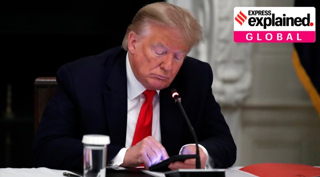 President Donald Trump looks at his phone, in the State Dining Room of the White House  in Washington. (AP Photo/Alex Brandon, File)