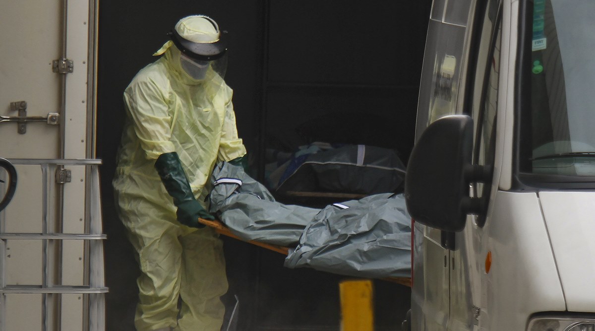 Health workers remove the body of a Covid-19 victim from a container, being used as a makeshift morgue, to turn over to a family outside the Joao Lucio public Hospital in Manaus, Amazonas state, Brazil, Monday, Jan. 4, 2021. (AP Photo/Edmar Barros)