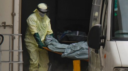Health workers remove the body of a Covid-19 victim from a container, being used as a makeshift morgue, to turn over to a family outside the Joao Lucio public Hospital in Manaus, Amazonas state, Brazil, Monday, Jan. 4, 2021. (AP Photo/Edmar Barros)
