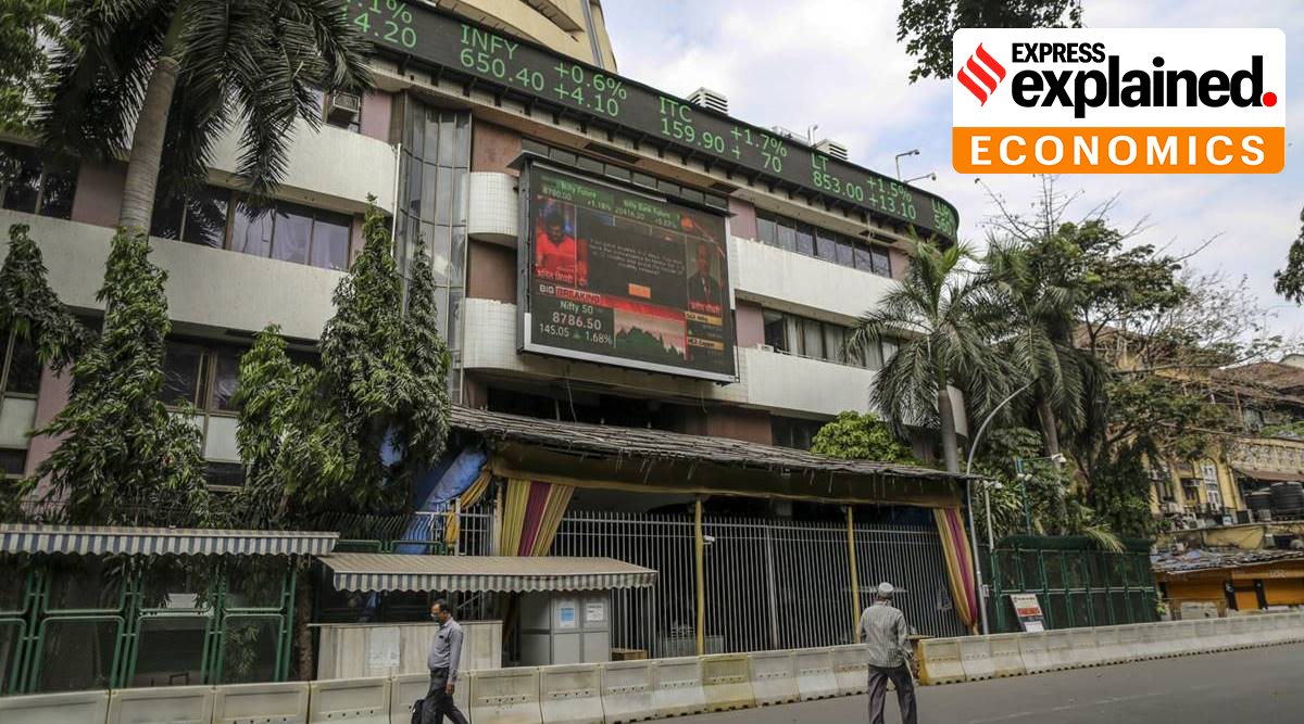 Pedestrians wearing protective masks walk past the Bombay Stock Exchange (BSE) in Mumbai, India, on Friday, March 27, 2020. (Photographer: Dhiraj Singh/Bloomberg)
