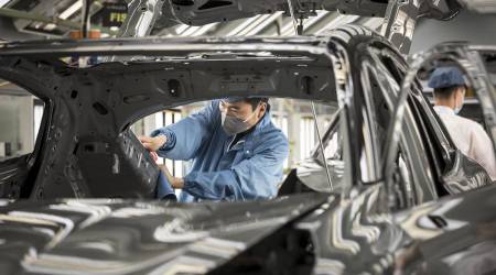 An employee wearing a protective mask works on a Lynk & Co. 05 crossover sport utility vehicle (SUV) in the paint shop at the Geely Automobile Holdings Ltd. plant in Ningbo, Zhejiang Province, China, on Tuesday, April 28, 2020. China's manufacturing purchasing managers' index (PMI) jumped to 52 in March, from an historic low of 35.7 in February as activity rebounded from disruptions caused by the coronavirus and containment measures. (Photographer: Qilai Shen/Bloomberg)