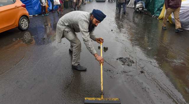 A farmer cleans an area at Ghazipur border during a protest against the new farm laws, in New Delhi (PTI Photo/Atul Yadav)(PTI01_02_2021_000095B)