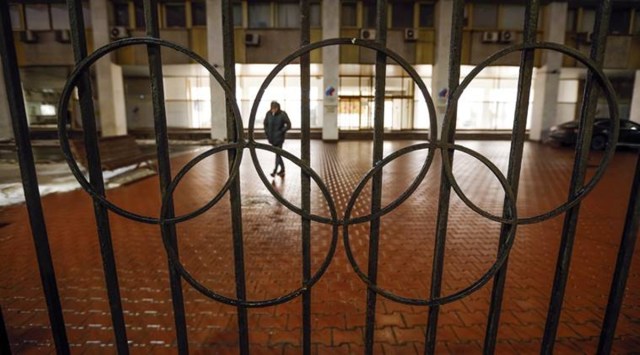 A man walks past a fence with Olympic Rings near the Russian National Olympic Committee building in Moscow, Russia, Thursday, Dec. 17, 2020. The Court of Arbitration for Sport confirmed Russia's flag and anthem are barred from next year's Olympics in Tokyo and the 2022 Winter Games in Beijing on Thursday. (AP)