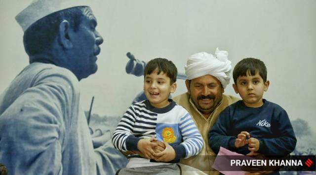 BKU President Naresh Tikait with his grandsons and a photo of his father Mahendra Singh Tikait seen in the picture, at his village in Muzaffarnagar, Uttar Pradesh. EXPRESS PHOTO BY PRAVEEN KHANNA 