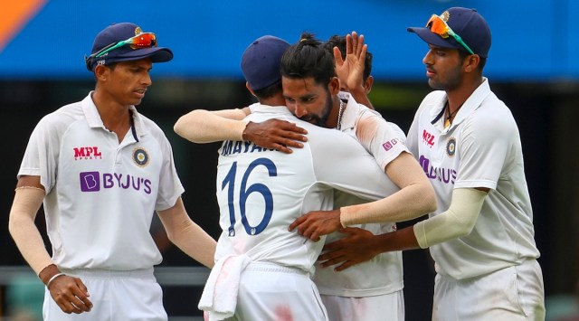 India's Mohammed Siraj, centre, celebrates with teammate Mayank Agarwal, second left, after taking his fifth wicket during play on day four of the fourth cricket test between India and Australia at the Gabba, Brisbane, Australia, Monday, Jan. 18, 2021. (AP Photo/Tertius Pickard)