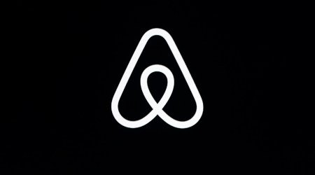 FILE - This Feb. 22, 2018, file photo shows an Airbnb logo during an event in San Francisco. Home-sharing site Airbnb posted a $3.9 billion loss in the fourth quarter of 2020 as it suffered from the pandemic downturn in travel and recorded one-time costs for becoming a public company. (AP Photo/Eric Risberg, File)