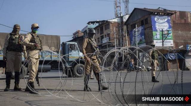 A paramilitary soldier stand near barbed wire at a checkpoint in Srinagar. (Express photo by Shuaib Masoodi/Representational)