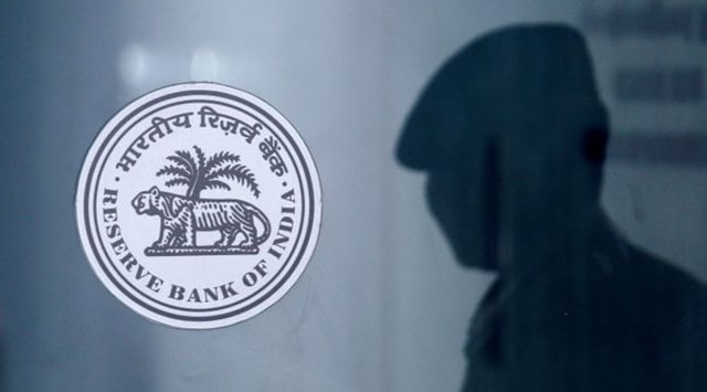 A security guard's reflection is seen next to the logo of the Reserve Bank Of India (RBI) at the RBI headquarters in Mumbai (Reuters)