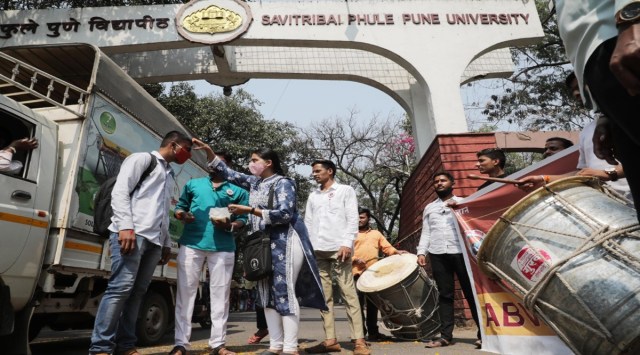 Members of ABVP celebrating the opening of senior colleges by distributing sweets and playing drums at Savitribai Phule Pune University (SPPU) on Monday. (Express photograph by Arul Horizon)