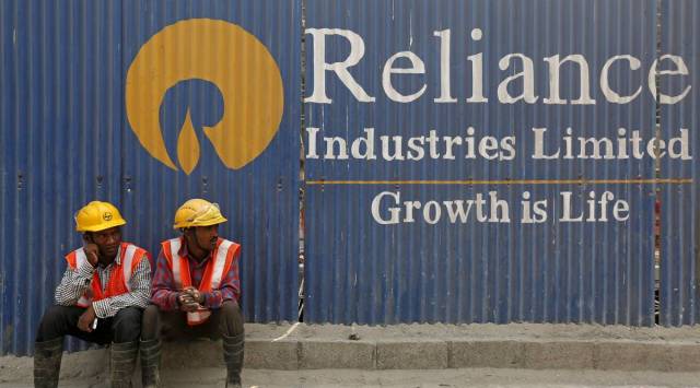 Labourers rest in front of an advertisement of Reliance Industries Limited at a construction site in Mumbai, India, March 2, 2016. (Image: REUTERS)