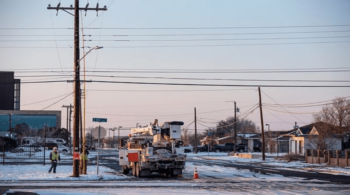 An Oncor Electric Delivery crew works on restoring power to a neighborhood following the winter storm that passed through Texas Thursday, Feb. 18, 2021, in Odessa, Texas. (Eli Hartman/Odessa American via AP)