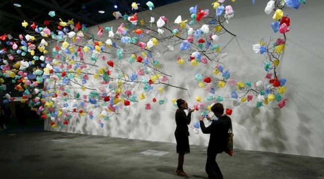 Visitors take a picture in front of the installation "Plastic Tree" by Cameroonian artist Pascale Marthine Tayou at the Art Unlimited exhibition at the Art Basel fair. (Photo: Reuters)