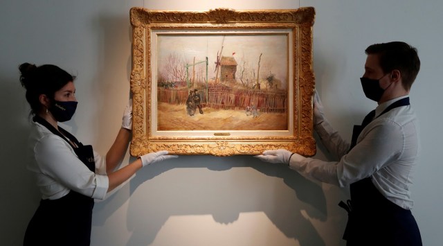 Sotheby's Paris employees pose with the 1887 painting of a Paris street scene "Scene de rue a Montmartre" by Dutch painter Vincent Van Gogh. (Photo: Reuters)