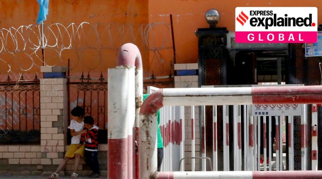 Children play outside the entrance to a school ringed with barbed wire, security cameras and barricades near a sign which reads "Please use the nation's common language" indicating the use of Mandarin in Peyzawat, western China's Xinjiang region. (AP Photo/Ng Han Guan, File)