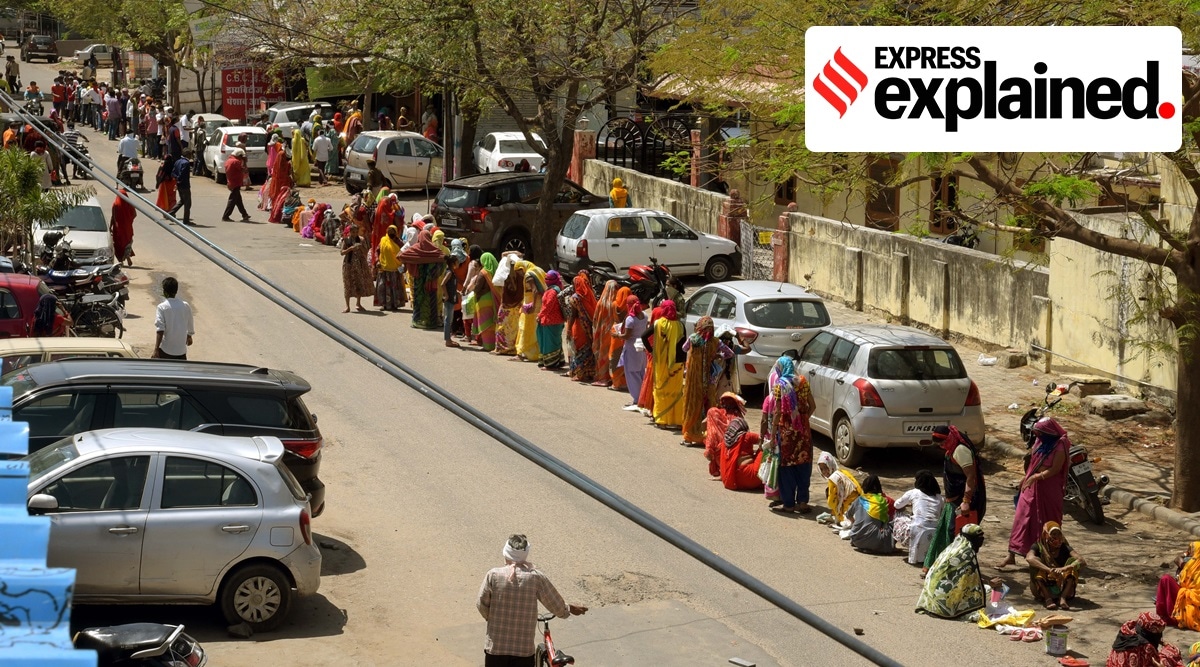 People wait to receive foodgrain under the public distribution system at a fair price shop in Jaipur during the nationwide lockdown imposed due to the Covid-19 pandemic, in March 2020. (Express Photo: Rohit Jain Paras, File)
