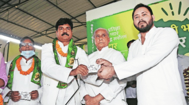 RJD leader Tejashwi Yadav presents member slips to former RLSP leaders in Patna on Friday.  (PTI)