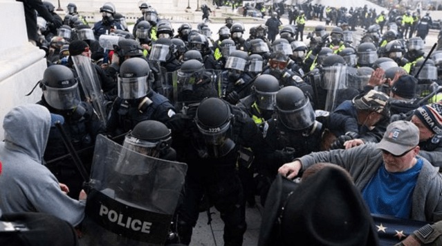 In this Jan. 6, 2021, file photo, U.S. Capitol Police push back rioters trying to enter the U.S. Capitol in Washington. A former State Department aide in President Donald Trump‚Äôs administration has been charged with participating in the deadly siege at the Capitol. (AP Photo/Jose Luis Magana, File)