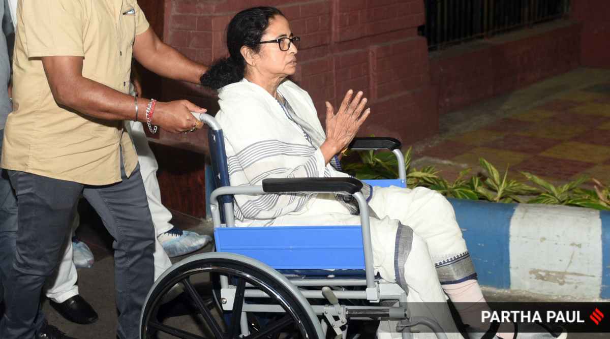 Mamata Banerjee emerged on a wheelchair after being discharged from the hospital on Friday. (Express Photo: Partha Paul)